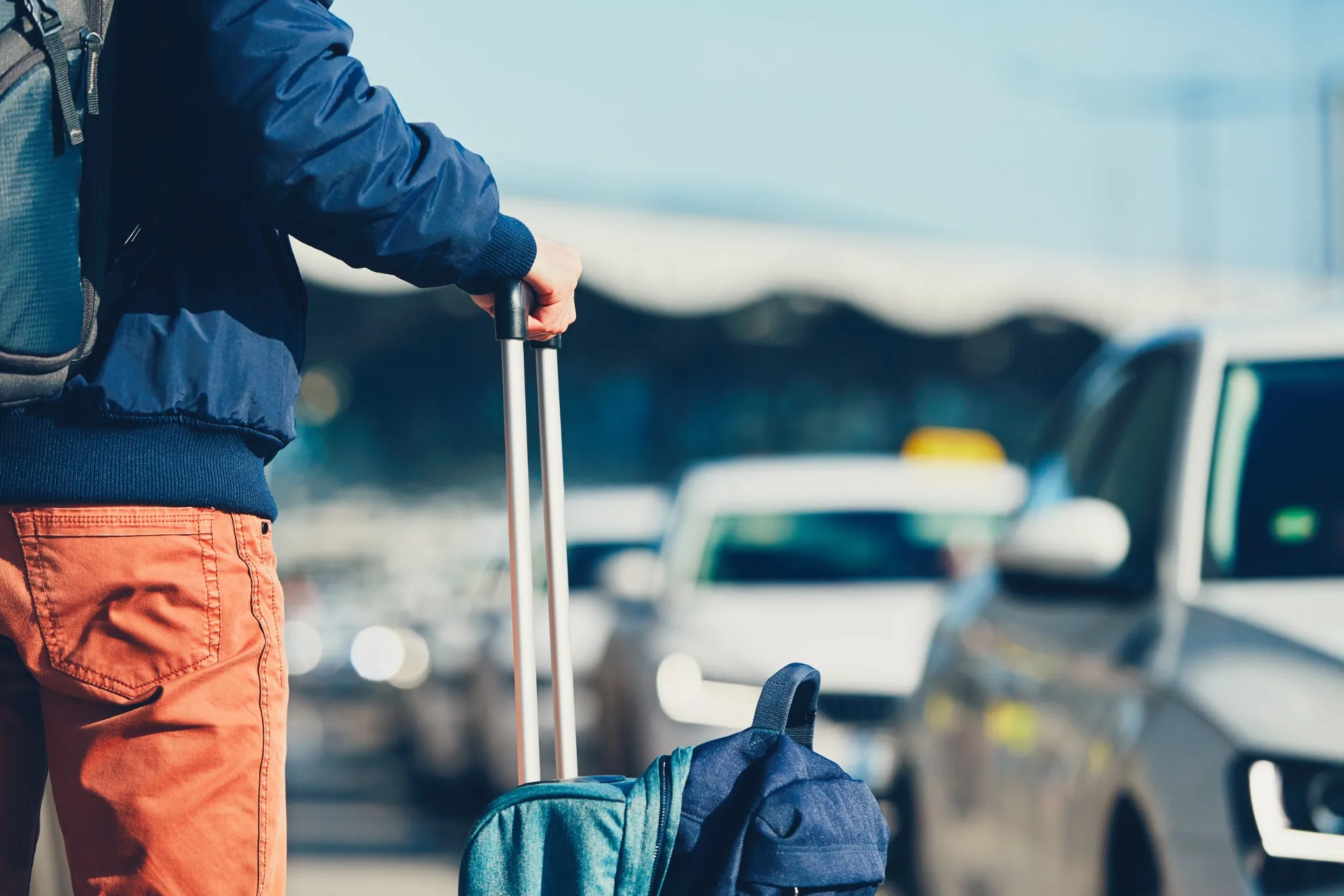 Traveler with luggage waiting for reliable airport transportation in New Hampshire